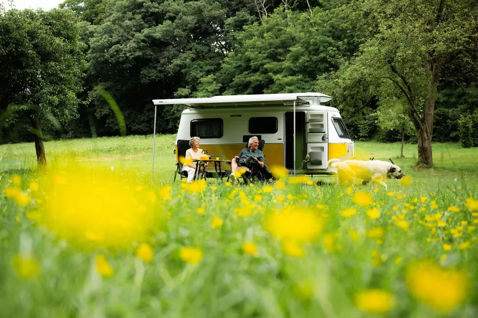 Ouder stel geniet van rust en ruimte op een kleine camping naast hun camper