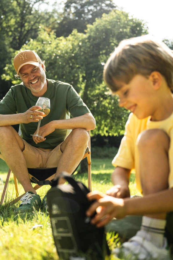 Man en kind genieten ontspannen buiten tijdens een caravanvakantie