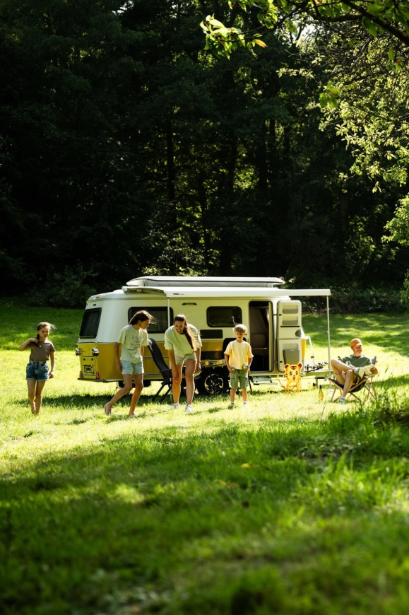 Gezin geniet buiten bij een moderne caravan op de camping