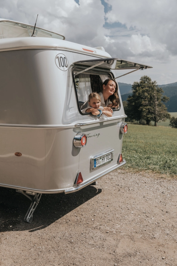Moeder en kind genieten bij een klassieke Eriba caravan op een zonnige dag