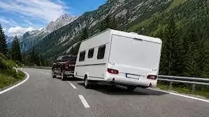 Auto met caravan op een bergweg — risico van overbelading bij heuvelachtig terrein