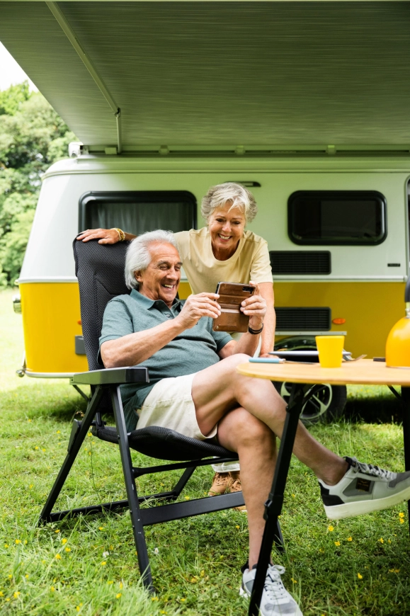 Stel geniet van het caravanleven buiten bij hun caravan op de camping