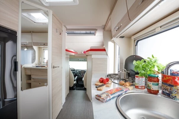 Modern en ruim interieur van een camper met keuken en zithoek klaar voor vertrek